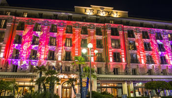 Façade illuminée en rouge de l'hôtel Le Royal à Nice